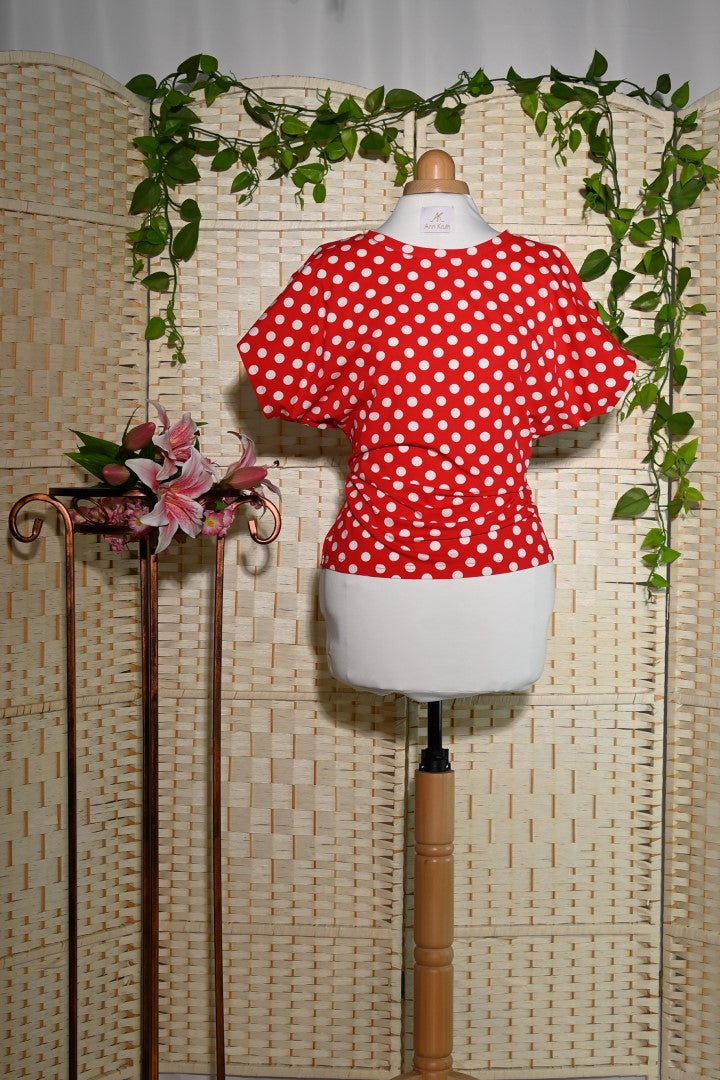 Rotes Shirt mit Punkten und angeschnittenem Ärmel auf einer Schneiderpuppe